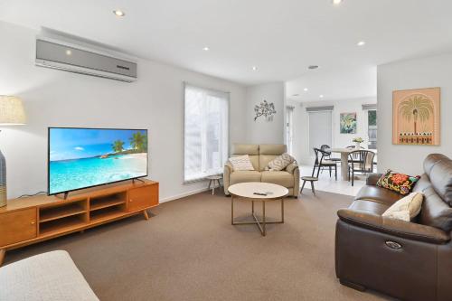 a living room with a flat screen tv and a couch at Retreat on Gairloch I Geelong River Hideaway in Geelong