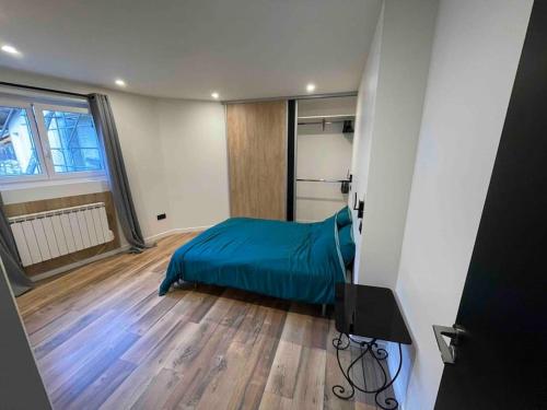 1 dormitorio con 1 cama con manta azul en Appartement 77 en Lans-en-Vercors