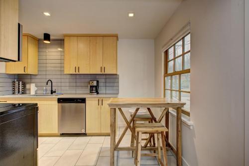 a kitchen with wooden cabinets and a table and stools at North End Bungalow 1919 in Boise