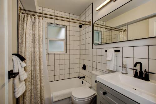 North End Bungalow 1919 في بويز: حمام مع مرحاض بالوعة ومرآة