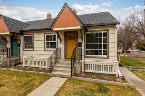a house with a yellow door and a sidewalk at North End Bungalow 1921 in Boise
