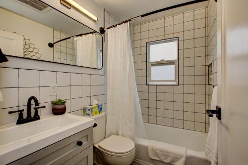 a bathroom with a sink and a toilet and a mirror at North End Bungalow 1921 in Boise