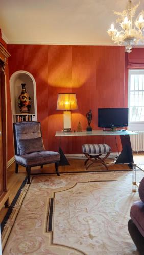 - un salon avec des murs rouges et une chaise dans l'établissement SUPREMATISME Appartement de Prestige, à Vierzon