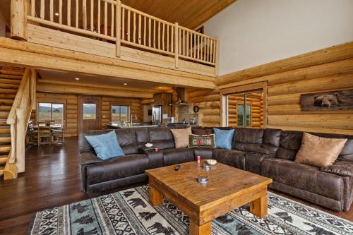 a living room with a leather couch and a coffee table at Stone Skipper Lodge by KABINO Waterfront Hot Tub Private Bath In Every Bedroom FirePit Mtn Views WiFi Grill in Island Park