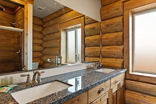 a bathroom with two sinks and a large mirror at Stone Skipper Lodge by KABINO Waterfront Hot Tub Private Bath In Every Bedroom FirePit Mtn Views WiFi Grill in Island Park