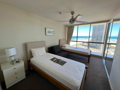 a hotel room with a bed and a bedroom with a view at Seacrest, Surfers Beach Front 15A in Gold Coast