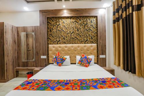 een slaapkamer met een groot bed en een houten muur bij FabExpress Shri Ram Kashi in Prayagraj