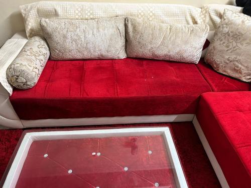a red couch with two pillows on top of it at Arora’s Mansion in Ghaziabad