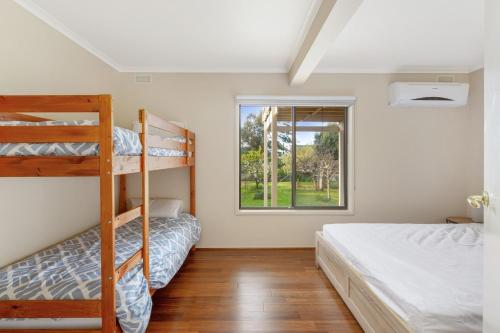 a bedroom with two bunk beds and a window at Seven on Ophir in Ventnor