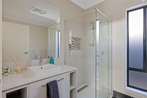 een witte badkamer met een wastafel en een douche bij KSea Castle in Cowes
