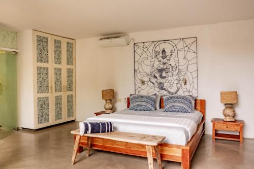 a bedroom with a bed and a bench in it at Villa Marie Clare in Seminyak