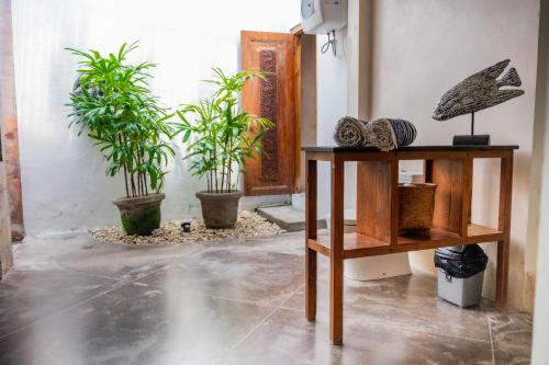 a room with two potted plants and a table at Villa Marie Clare in Seminyak