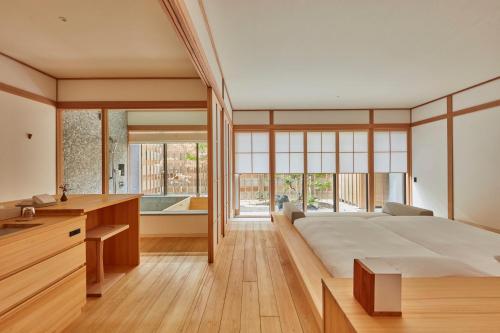 a bedroom with a large bed and a tub at Azumi Setoda in Onomichi