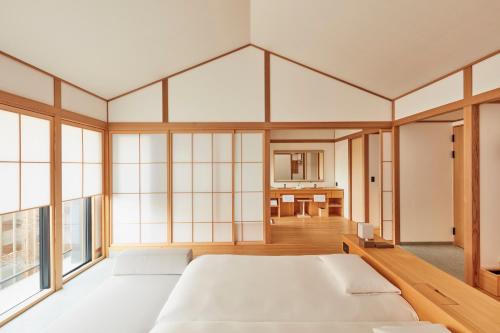 a large bedroom with a large bed and windows at Azumi Setoda in Onomichi