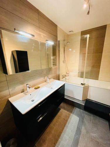 La salle de bains est pourvue d'un lavabo blanc et d'une baignoire. dans l'établissement CATHÉDRALE/Cossu/Confortable/Spacieux, à Reims