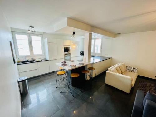 une cuisine et un salon avec un canapé et une table dans l'établissement CATHÉDRALE/Cossu/Confortable/Spacieux, à Reims