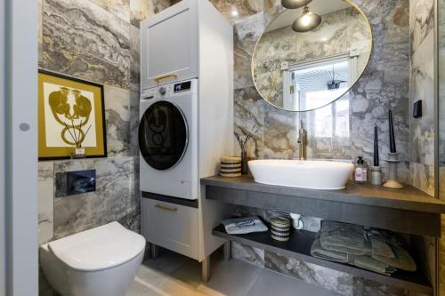a bathroom with a sink and a washing machine at Brand New Old Town Apartment With Terrace in Haapsalu