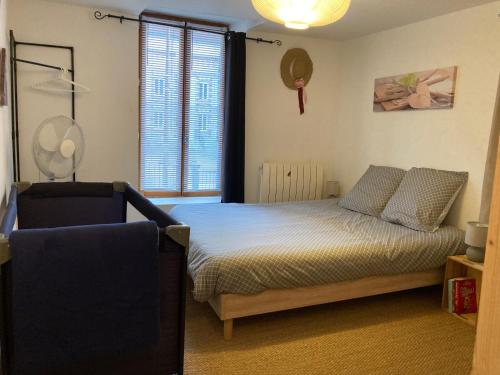 a bedroom with a bed and a chair and a window at Le Gambetta - nouveau propriétaire in Estissac