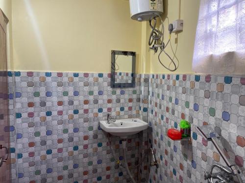 W łazience znajduje się umywalka i prysznic. w obiekcie Jasmine Homestay Darjeeling w mieście Dardżyling