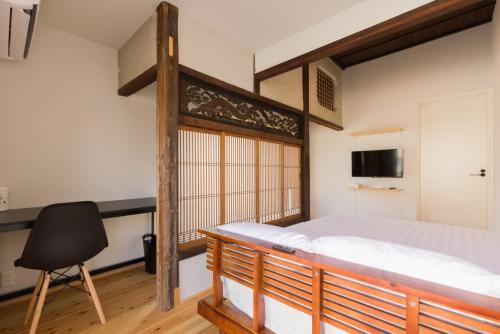 a bedroom with a large wooden bed and a chair at FARMSTAY miyuki-street "Goen" in Ukiha