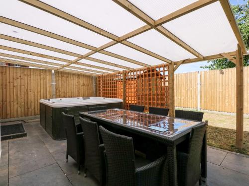 a patio with a pergola and a table and chairs at The Beach House in Mablethorpe