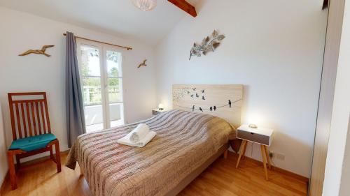 een slaapkamer met een bed met twee handdoeken erop bij Le Cottage des Fontenelles in Coëx