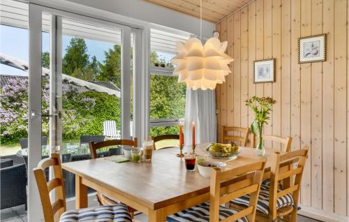 a dining room with a wooden table and chairs at Beautiful Home In Dronningmølle in Dronningmølle