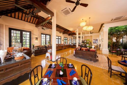 una sala de estar abierta con mesas y sillas en Victoria Hoi An Beach Resort & Spa en Hoi An