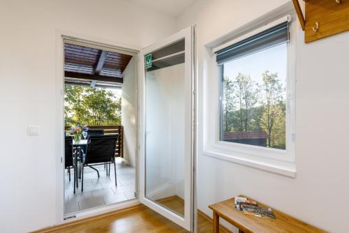 een kamer met ramen en een eetkamer met een tafel bij Apartman Medved in Slunj