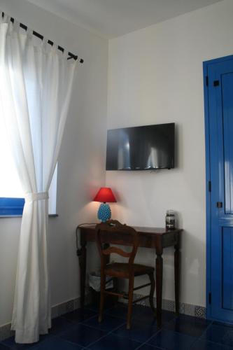 a desk with a lamp and a chair next to a window at Avocado B&B Beyond in Giardini Naxos