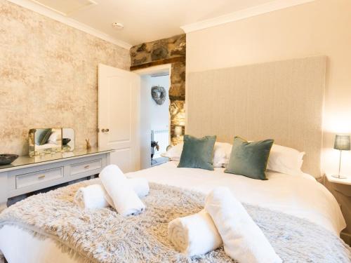 1 dormitorio con 1 cama blanca grande con almohadas blancas en Bwthyn Clyd, en Dyffryn