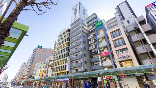 a tall building on a city street with buildings at Toyoko Inn Tokyo Kamata Higashi-guchi in Tokyo