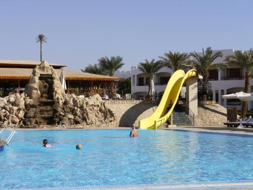 a group of people in a swimming pool with a slide at Happy Life Village Dahab in Dahab