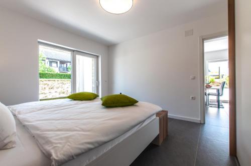 a bedroom with a bed with green pillows on it at Apartments Ursus in Bled