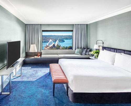 シドニーにあるインターコンチネンタル シドニーの大きなベッドと大きな窓が備わるホテルルームです。