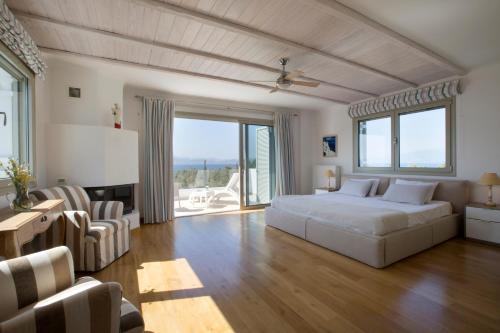 a bedroom with a white bed and a living room at Villa Elena Loutraki in Loutraki