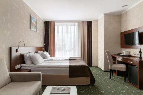 Habitación de hotel con cama y sofá en Optima Collection Gallery Poltava, en Poltava