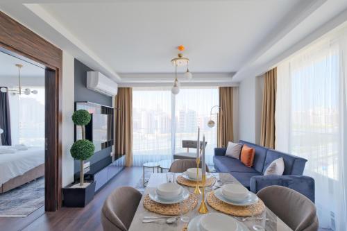 a living room with a blue couch and a table at Air Başakşehir Residence by NewInn in Basaksehir
