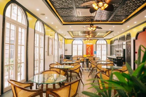 een restaurant met tafels, stoelen en ramen bij Alee HaLong Hotel in Ha Long