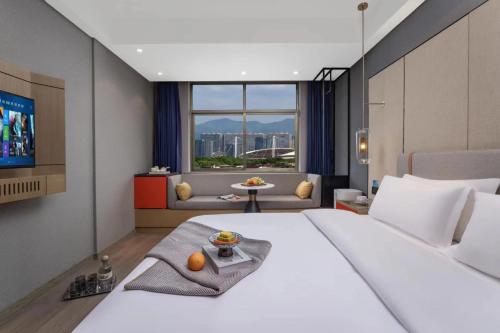 Habitación de hotel con cama grande y TV en Yiwu Boyi Meiju Hotel义乌市泊忆酒店 en Yiwu