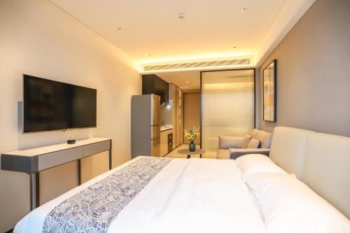 a bedroom with a white bed and a television at Canopy Executive Apartments - Shenzhen Futian Center in Shenzhen