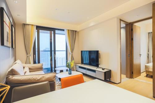 a living room with a couch and a tv at Canopy Executive Apartments - Shenzhen Futian Center in Shenzhen