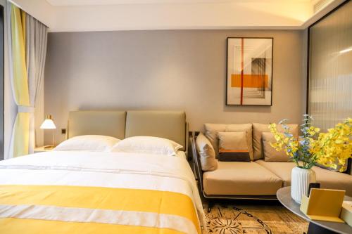 a bedroom with a large bed and a couch at Canopy Executive Apartments - Shenzhen Futian Center in Shenzhen
