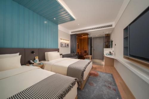 a hotel room with two beds and a flat screen tv at CityNote Hotel - Guangzhou Beijing Road Sun Yatsen Memorial Hall Metro Station in Guangzhou