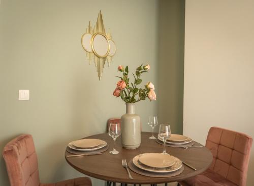 tavolo da pranzo con sedie e vaso con fiori di Koulas luxury apart by homebrain a Alexandroupoli