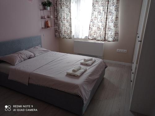 1 dormitorio con 1 cama con 2 toallas en Уютна къща, en Sliven