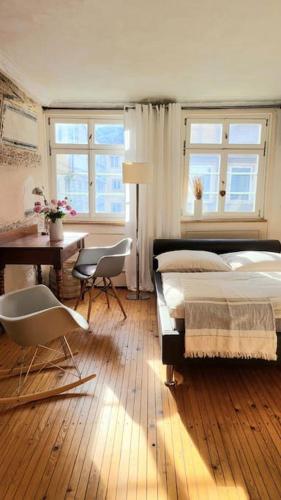 a bedroom with a bed and a desk and chairs at Historisches Denkmal im Herzen der Altstadt in Esslingen