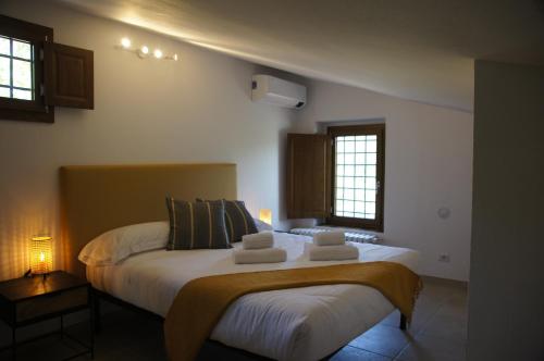 una camera da letto con un grande letto con lenzuola e cuscini bianchi di Il Sottolo a Firenze