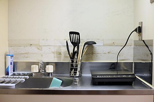 a kitchen counter with a sink with utensils at KB House Shinjuku Double room Free wifi! in Tokyo