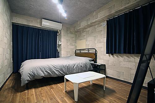 a bedroom with a bed and a table at KB House Shinjuku Double room Free wifi! in Tokyo
